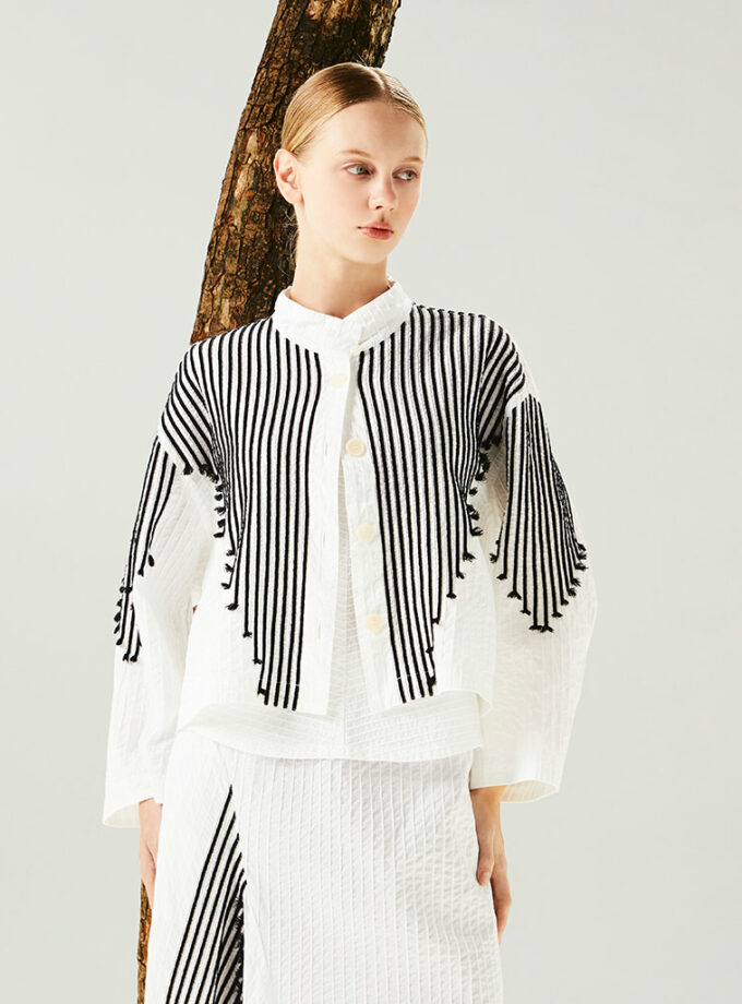SS25 Lady Lawn Jacket 1111946 YaccoMaricard เสื้อแจ็คเก็ตนี้มีความโดดเด่น ด้วยตัวเสื้อทรงบ็อกซ์ความยาวครอป แขนเสื้อทรงพอง และเชือกแบบตัว V